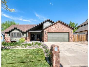 Charming exterior showcasing a well-manicured front yard and a brick and siding facade under a blue sky at 13830 Silverton Dr, Broomfield, CO 80020