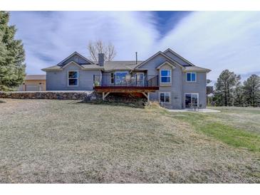 Spacious backyard featuring a deck, patio, and lush lawn, perfect for outdoor living at 10510 Inspiration Dr, Parker, CO 80138