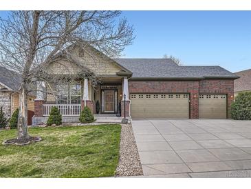 Charming brick and siding home with a three-car garage and a well-manicured lawn at 1978 Granger Cir, Castle Rock, CO 80109