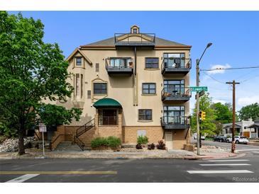 Multi-level condo building boasting several balconies, a street view and manicured landscaping at 3299 Lowell Blvd # 204, Denver, CO 80211