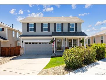 Charming two-story home features a well-manicured lawn, grey siding, and a welcoming front porch at 11866 High Desert Rd, Parker, CO 80134