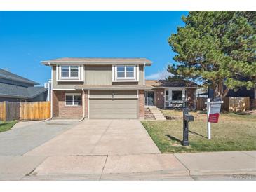 Charming two-story home with a well-maintained lawn, attached garage, and mature trees at 5429 S Waco St, Centennial, CO 80015