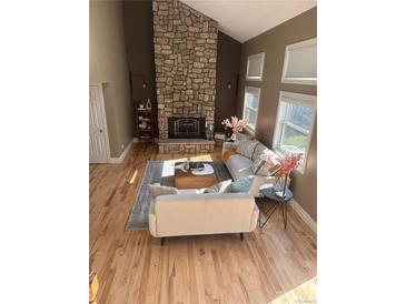 Bright living room with a stone fireplace, hardwood floors and lots of natural light at 5429 S Waco St, Centennial, CO 80015