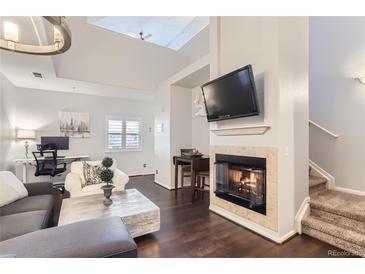 Bright and modern living room with high ceilings, fireplace, and hardwood floors at 5420 Allison St # 202, Arvada, CO 80002