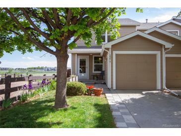 Inviting home with a charming front yard, lush lawn, lovely flowers, and an attached single-car garage at 2296 E 109Th Dr, Northglenn, CO 80233