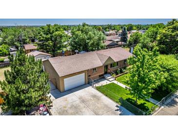 Charming ranch-style home features a well-maintained lawn, mature trees, and an attached two-car garage at 9170 Aspen Dr, Thornton, CO 80229