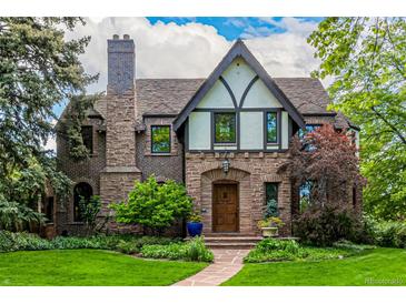 Charming Tudor-style home with a stone facade, lush landscaping, and a welcoming front entrance at 1795 N Monaco St Pkwy, Denver, CO 80224