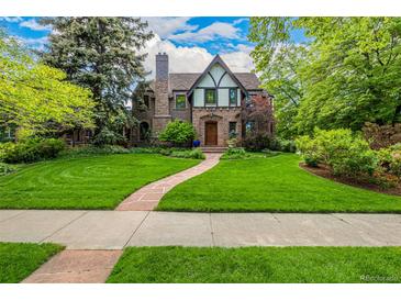 Charming stone Tudor home with a manicured front yard and a stone walkway leading to the front door at 1795 N Monaco St Pkwy, Denver, CO 80224