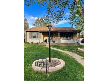Charming single-story home featuring a well-manicured lawn, brick accents, and inviting curb appeal at 424 S Leyden St, Denver, CO 80224