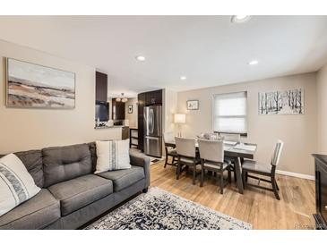 Inviting living room showcases a gray sofa, artwork, and an adjacent dining area at 424 S Leyden St, Denver, CO 80224