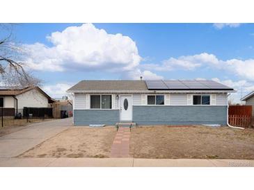 Charming single-story home with a well-maintained lawn and solar panels on the roof at 5411 Chandler Way, Denver, CO 80239
