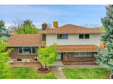 Charming two-story home featuring brick and siding exterior with a well-manicured lawn at 7076 S Spruce W Dr, Centennial, CO 80112