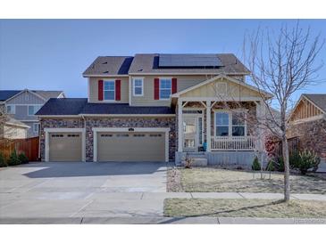 Charming two-story home featuring a stone facade, three-car garage, and solar panels, perfect for suburban living at 3164 S Kirk Way, Aurora, CO 80013