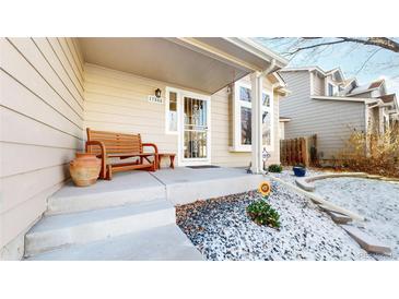 Charming front porch with a wooden bench, concrete steps, and decorative landscaping at 17588 E Dickenson Pl, Aurora, CO 80013