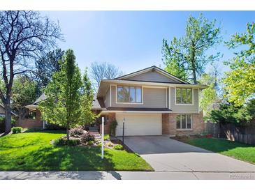 Two-story home with a two-car garage, neutral siding, brick accents, and well-maintained landscaping at 4626 E Links Dr, Centennial, CO 80122