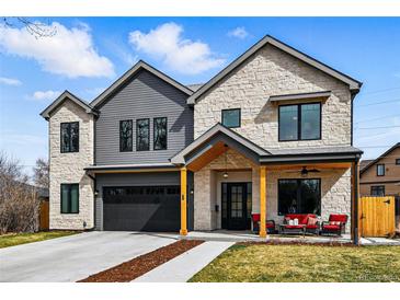 Inviting two-story home boasts a stone and gray exterior, attached two car garage, and covered front porch at 428 Pontiac St, Denver, CO 80220