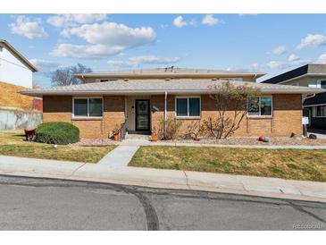 Charming brick home with a well-maintained lawn and inviting entrance at 9942 Lane St, Thornton, CO 80260