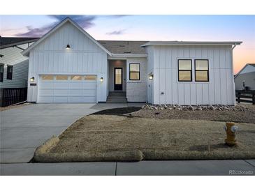 Charming single-Gathering home with modern farmhouse exterior, large windows and an attached two car garage at 11442 Autumn Moon St, Littleton, CO 80125