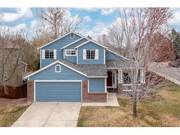 Charming two-story home with a blue exterior, brick accents and well-maintained landscaping at 1898 Wilson Cir, Erie, CO 80516