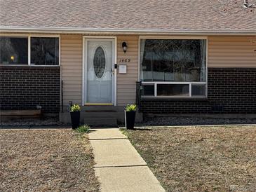 Charming front door with decorative glass and planters along the walkway at 1469 S Reed St, Lakewood, CO 80232
