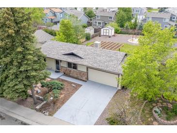 Charming ranch-style home featuring a well-maintained lawn and a large driveway leading to an attached two-car garage at 6147 Dunraven St, Golden, CO 80403