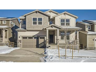 Two-story house with gray siding, a large garage, and snowy landscaping at 5581 Wisteria Ave, Firestone, CO 80504