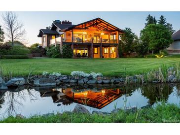 Stunning two-story home featuring a beautiful pond and lush green lawn at 8387 N Sunburst Trl, Parker, CO 80134