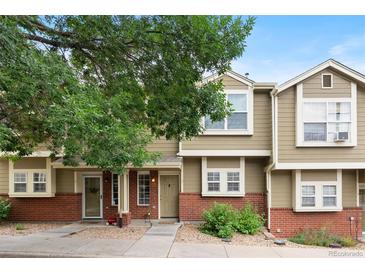 Charming townhome featuring a brick facade and mature trees, creating a welcoming curb appeal at 9138 Gale Blvd # 2, Thornton, CO 80260