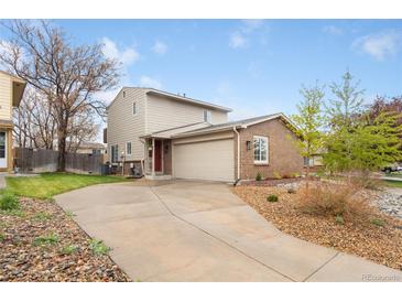 Two-story home with brick accents, attached garage, front yard with rock landscaping and extended driveway at 12606 Fairfax St, Thornton, CO 80241