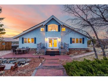 Charming home with a manicured lawn, complemented by a brick patio perfect for outdoor entertainment, with a mountain view at 5271 N Mesa Dr, Castle Rock, CO 80108