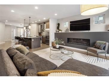 Open-concept living room features fireplace, TV, and view into the modern kitchen with an island at 1815 Grove St, Denver, CO 80204