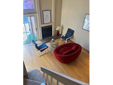 Cozy living room with fireplace, stylish seating, and natural light from a large window at 4899 S Dudley St # K18, Littleton, CO 80123