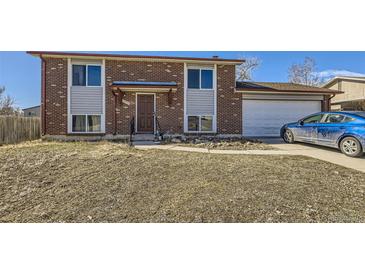 Charming two-story brick home featuring an attached garage and a well-maintained lawn at 10932 W 107Th Ave, Broomfield, CO 80021