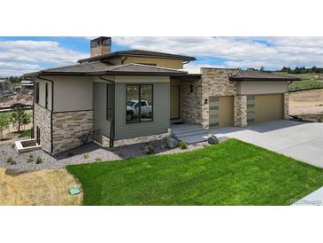 Beautiful home with a modern design, stone accents, and a well-manicured lawn at 6196 Oxford Peak Ln, Castle Rock, CO 80108