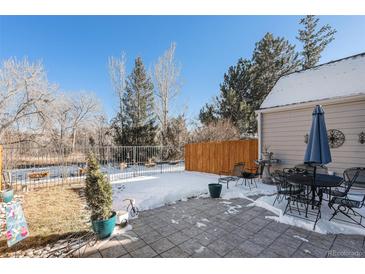 A backyard patio, surrounded by a fence and trees, offers a serene outdoor space at 10000 E Yale Ave # 7, Denver, CO 80231