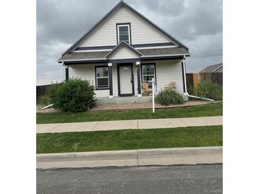 Charming home with a well-manicured lawn, inviting front porch and beautiful curb appeal at 2874 Rose Hill St, Strasburg, CO 80136