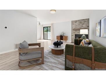Sunlit living room boasts modern furnishings, fireplace, and sliding glass doors to a balcony at 580 Vance St # A, Lakewood, CO 80226