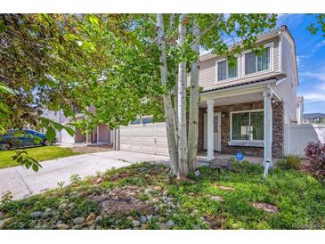 Charming two-story home featuring a stone facade, attached garage, and landscaped front yard with mature trees at 4435 Andes Ct, Denver, CO 80249