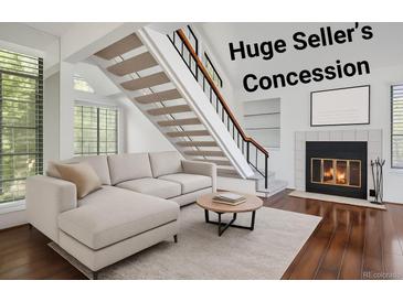 Cozy living room features a fireplace, stairs, and hardwood floors, creating a warm and inviting atmosphere at 4802 E Kentucky Ave # E, Denver, CO 80246