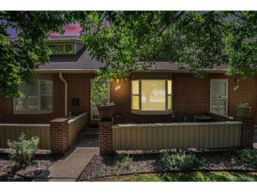 Charming brick townhome featuring a bay window, neat landscaping, and a welcoming front entrance at 3300 W Florida Ave # 51, Denver, CO 80219
