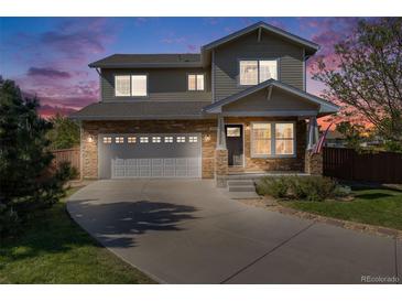 Charming two-story home with stone accents, well-manicured lawn, and inviting curb appeal at dusk at 19294 E Warren Pl, Aurora, CO 80013