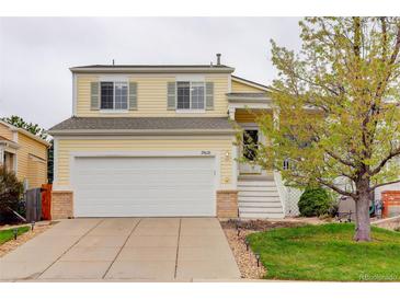Charming yellow two-story home with a well-maintained front yard and a two-car garage at 20626 Willowbend Ln, Parker, CO 80138