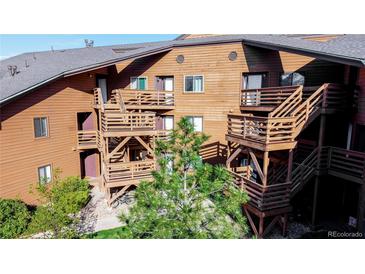 Exterior view of brown building featuring multiple balconies, staircases and mature landscaping at 6110 Habitat Dr # 2, Boulder, CO 80301