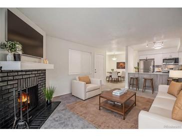 Inviting living room with a cozy fireplace and open floor plan at 14704 E 2Nd Ave # E307, Aurora, CO 80011