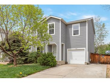 Charming two-story home featuring gray siding, well-kept landscaping, and an attached one car garage at 1365 Waxwing Ave, Brighton, CO 80601
