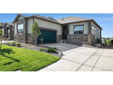 Charming home featuring stone accents, a well-manicured lawn, and a driveway leading to an attached two-car garage at 811 W 128Th Pl, Westminster, CO 80234