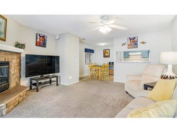 Cozy living room features a fireplace and sliding glass door leading to patio at 3600 S Pierce St # 7-104, Denver, CO 80235