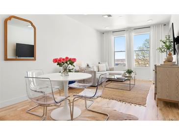 Bright living area featuring a dining table and large windows with natural light and city views at 2851 W 52Nd Ave # 404, Denver, CO 80221