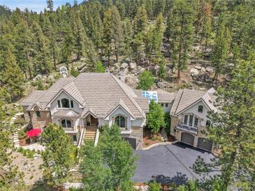 Beautiful exterior view of a house nestled amongst the trees in a mountainous location at 4158 Wild Flower Ct, Evergreen, CO 80439