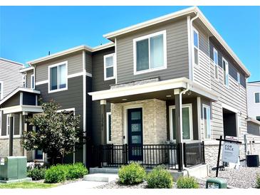 Modern two-story home featuring a stylish facade, stone accents, and a welcoming front porch at 12301 Festival Ln, Thornton, CO 80241